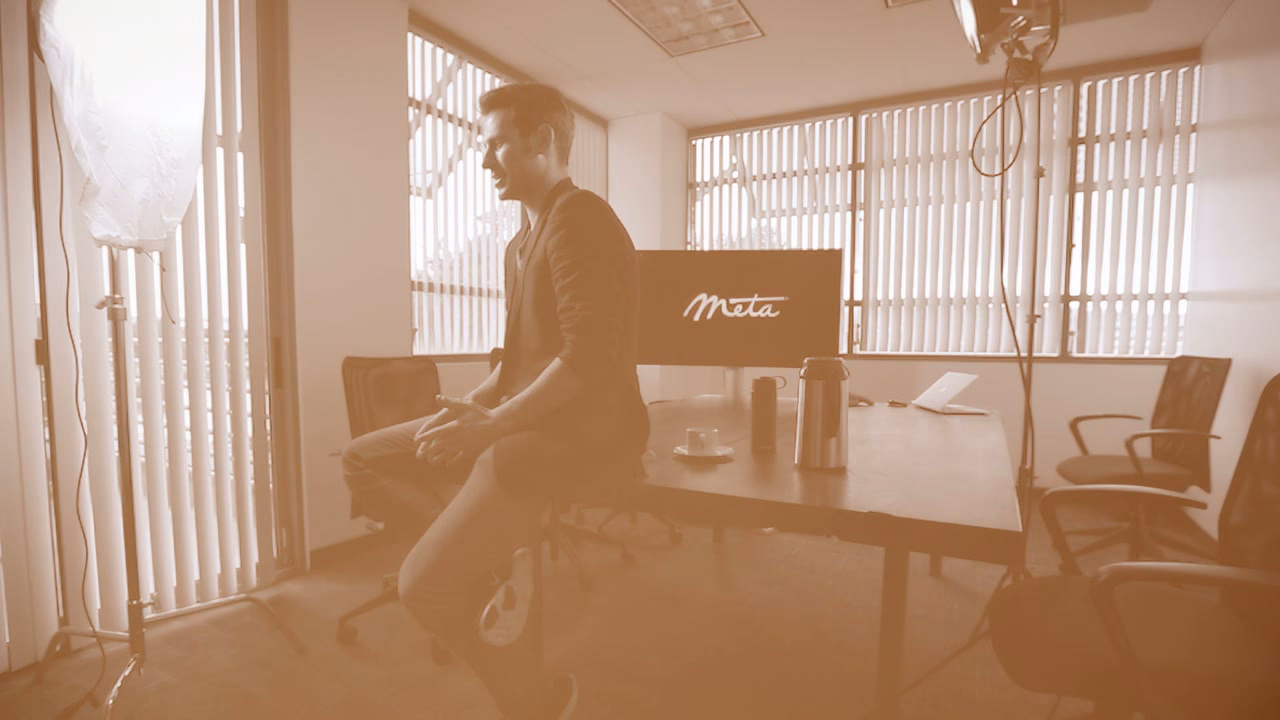 A wide of the office interview setup, a softbox at the window and the Meta logo on a monitor